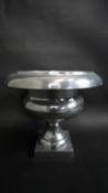 A pewter campana form pedestal bowl on square base. H.31 W.34 D.34