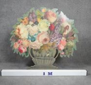 A cut out wooden screen with easel back, with decoupage flowers in a painted urn. Signed A.