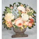 A cut out wooden screen with easel back, with decoupage flowers in a painted urn. Signed A.