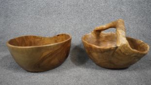 Two large carved natural wood fruit bowls, one with a handle. Signed to the base. H.26 W.33 D.33cm