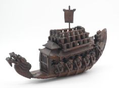 A Chinese late Qing period carved hardwood dragon ship with detachable lid and central hollow