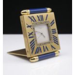 Must de Cartier, a quartz travel clock, the square lacquered brass case with blue enamelled batons