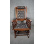 A late 19th century carved walnut American style rocking chair in floral cord upholstery. H.104cm