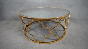 A gilt metal circular low table with pierced sides and inset mirrored glass top. H.35 D.79cm