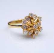 A yellow metal (tested higher than 9 carat) floral design cluster dress ring. Set with thirteen