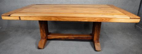 A hardwood planked top refectory style dining table with cleated ends on stretchered platform