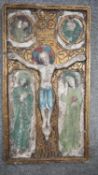 An early 20th century ceramic relief plaque of the Crucifixion with painted and gilded details. H.59