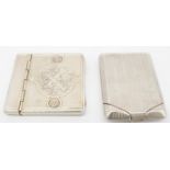 Two sterling silver match books. One French with repousse design, one side with oval cartouche