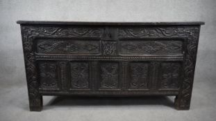 A 17th century oak coffer with carved floral panels to the lid, front and sides, dated and