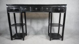A Chinese black lacquered console table fitted with frieze drawers on square stretchered open