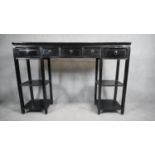 A Chinese black lacquered console table fitted with frieze drawers on square stretchered open