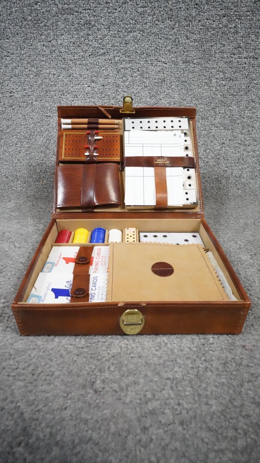 A leather cased lockable travelling gaming set, including dice, gaming pieces, cribbage, chess board