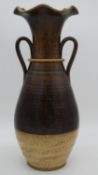 A large art pottery glazed vase with twin handles and fluted edge. H.60cm