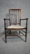 A late 19th century mahogany and satinwood inlaid armchair with Art Nouveau style tulip carved