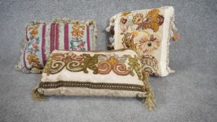 Three 20th century tapestry floral design cushions with silk tassle edging. One with a raspberry