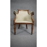 A William IV mahogany framed tub shaped library armchair with scroll arms and geometric upholstery