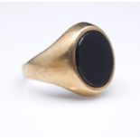 An vintage 9 carat gold and onyx oval signet ring. Hallmarked: London, 375, indistinct makers