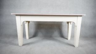 A distressed painted farmhouse dining table on square tapering supports with modern. H.76 W.153 D.61