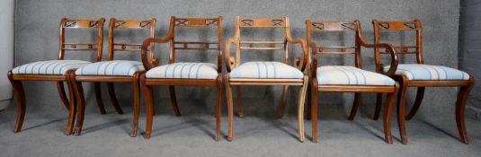 A set of six mahogany bar back Regency style dining chairs on sabre supports made up of three carver