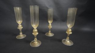 Four Venetian style hand blown glass champagne flutes with gold leaf in the glass and ruffled