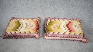 A pair of tapestry silk backed floral and geometric design cushions with silk tassel edging. H.28