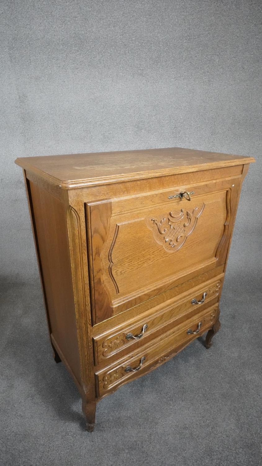 A Continental light oak drinks cabinet with carved fall above two drawers on cabriole supports. H. - Image 2 of 8
