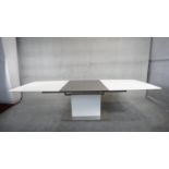 A contemporay Bo Concept extending dining room table with integral folding central leaf on