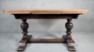 A mid century oak Jacobean style draw leaf dining table on baluster turned stretchered supports. H.