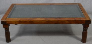An Indian hardwood coffee table with plate glass on a metal lattice work inset top. H.41 L.132 W.