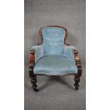 A Victorian mahogany framed armchair in deep buttoned upholstery on baluster turned supports. H.