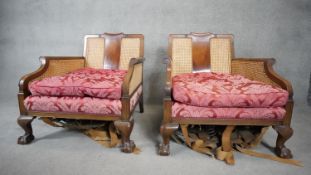 A pair of mid century Georgian style mahogany bergere armchairs with caned backs and sides raised on