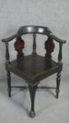 An ebonised corner armchair with Arts and Crafts style pokerwork daffodil decoration to the back