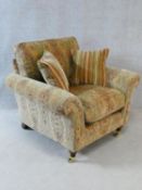 A Parker Knoll Burghley armchair in Baslow Medalli gold upholstery raised on turned tapering