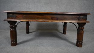 An Indian teak metal bound low table on circular supports. H.39 L.93 D.60cm