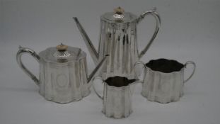 An antique silver plated engraved four piece coffee and tea set. The coffee and tea pots have