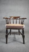 A 19th century elm captain's armchair on turned stretchered supports. H.80 W.68 D.62