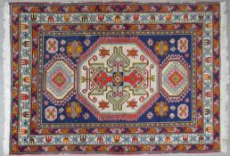 A Russian Kazak rug with stylised floral triple hooked medallions on sapphire ground. L.225 W.150cm