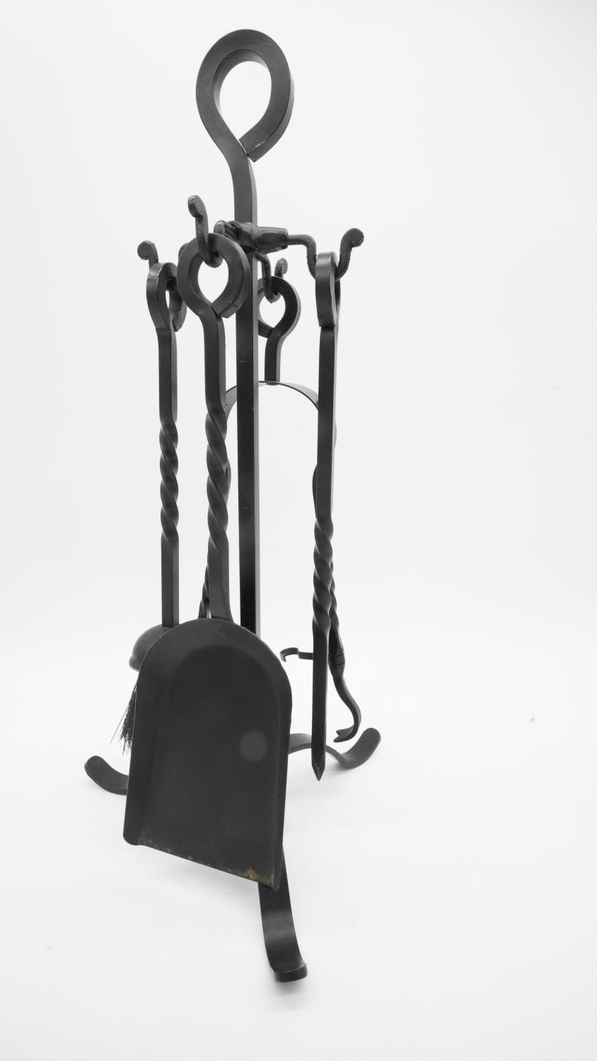 A cast iron stand with fire tools. Handles with twisted design. H.56cm