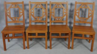 A set of four Chinese influenced hardwood dining chairs with panel seats on square section supports.