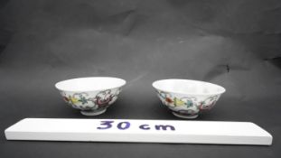 A pair of Chinese Qing period Famille Rose porcelain bowls. Decorated with flowers, fruit and
