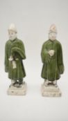A pair of Chinese Tang style terracotta figures of attendants with green glazed robes. H.26cm