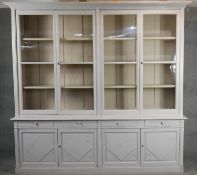 A large painted 19th century style kitchen dresser or library bookcase with glazed panel doors