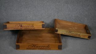 A set of three graduating twin handled trays marked Harrod's.