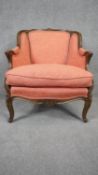 A Louis XV style carved walnut framed armchair in floral blush upholstery on cabriole supports. H.