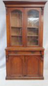 A Victorian mahogany library bookcase with arched glazed upper section enclosing bookshelves above