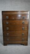 A mid century oak tall chest of five drawers on bracket feet. H.103 W.76 46