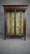 An Edwardian mahogany and satinwood inlaid display case with circular pane astragal glazed doors