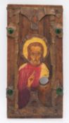 A painted religious idol on wood panel, with copper and green glass detailing. H.37 W.18cm