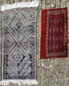 A Bokhara style rug with repeating stylised star motifs on a burgundy ground and an Eastern rug with