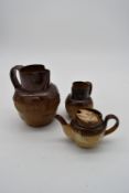 Two Royal Doulton Lambeth jugs and a similar tea pot.
